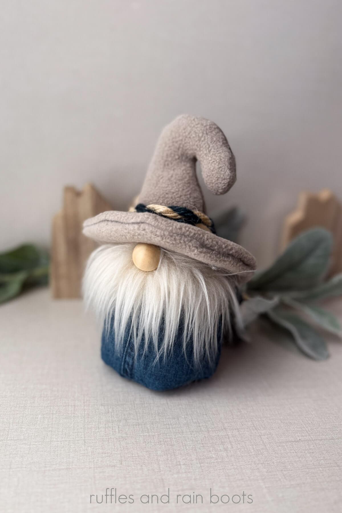 Vertical image of a summer, nautical gnome made with jean and fleece material with a blonde beard and rope accent.