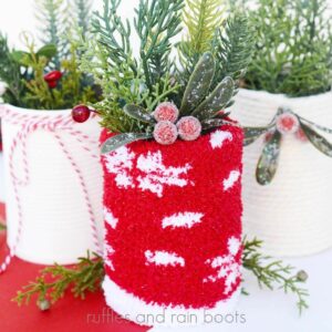 Square, close up image of three tin can planters made with recycled tin cans, socks, and yarn.