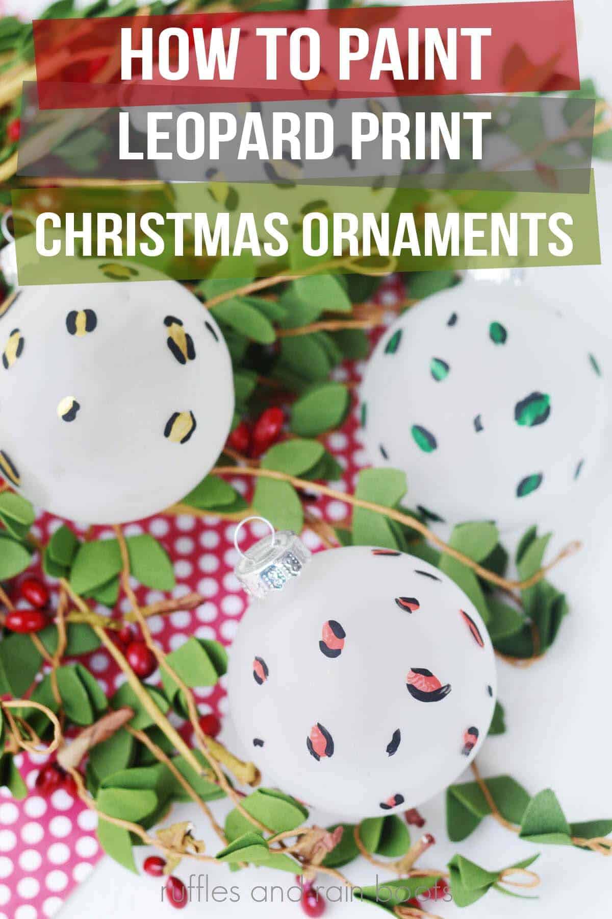 Vertical image of a set of red, green, and gold animal print Christmas baubles on a bed of holly with text which reads how to paint leopard print Christmas ornaments.