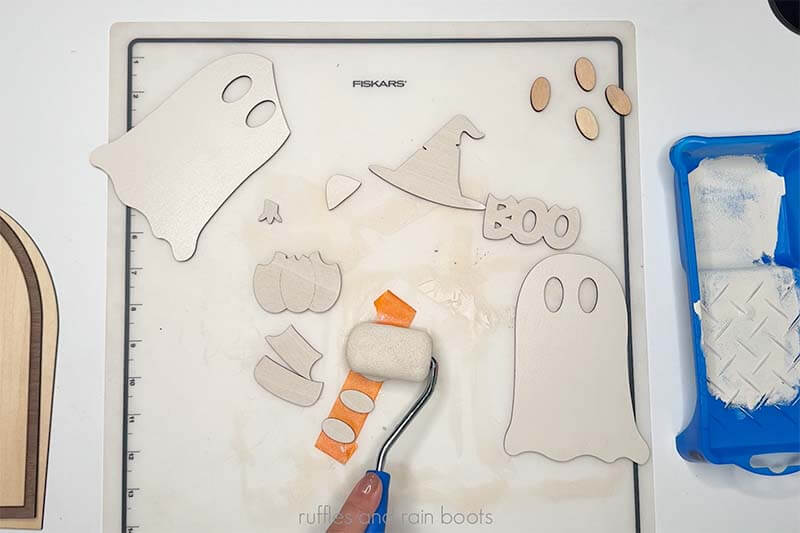 Crafter using a roller to quickly prime and paint all ghost sign elements.