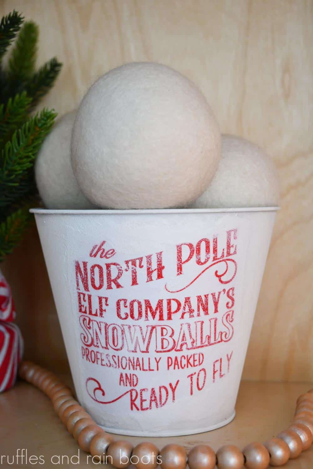 Vertical image of a cute snowball bucket with a frosted metal bin on a wood background.