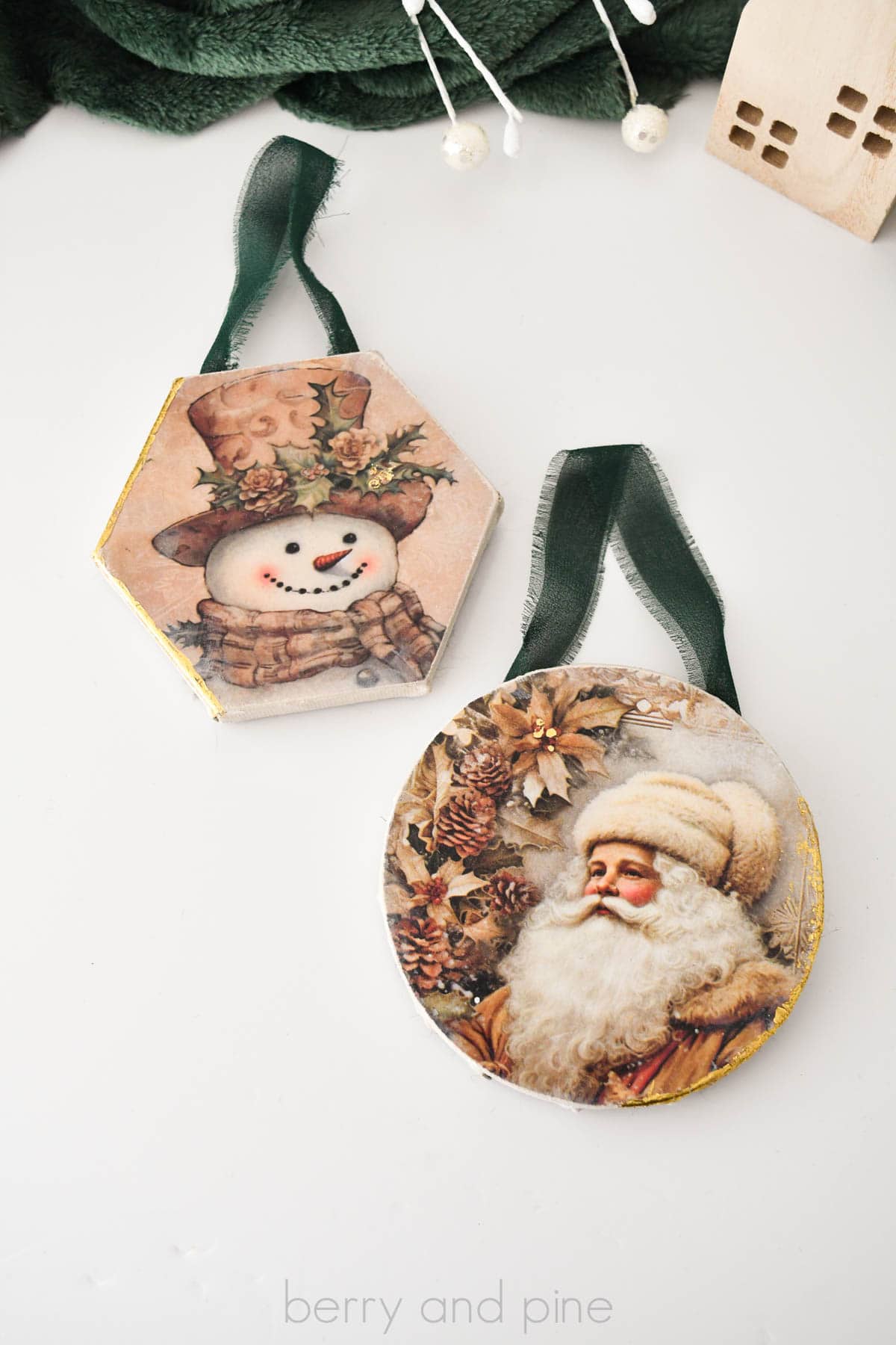 Vertical image of two Dollar Tree canvas Christmas ornaments made with paper and decoupage.