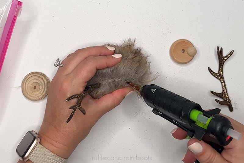 Crafter gluing in Dollar Tree antlers for the reindeer.