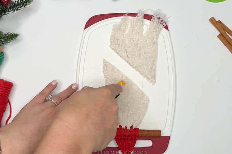 Crafter using a rotary blade to trim a gnome ornament beard.