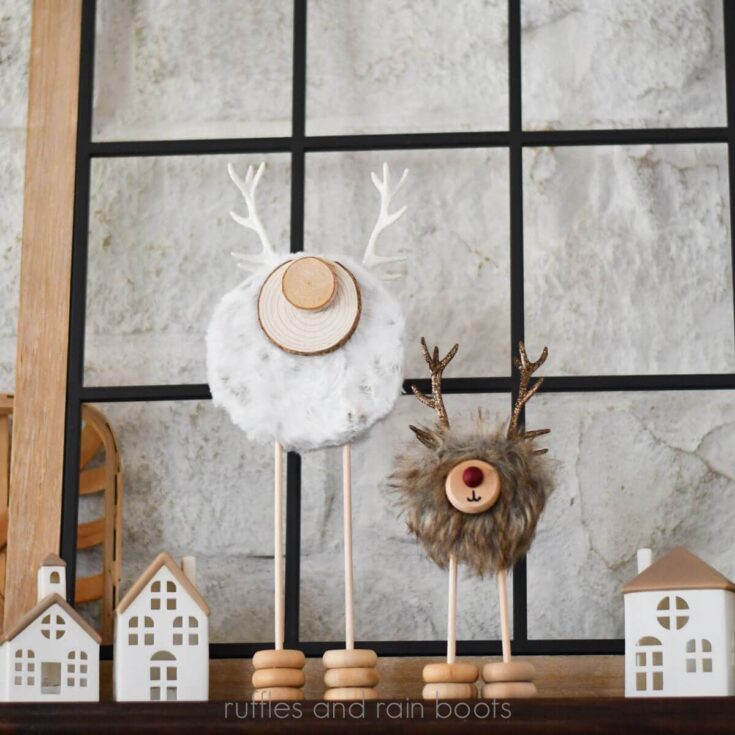 Dollar Tree antlers and foam balls made into standing reindeers displayed against a stone wall with Christmas decor.