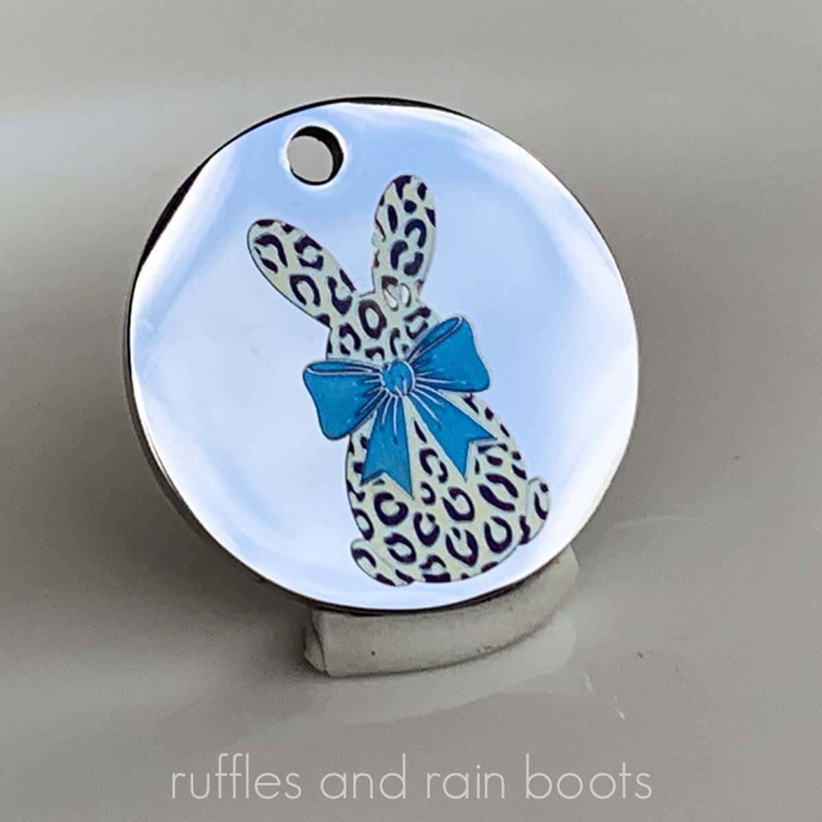 Close up color engraving on a metal pendant using the xTool F2; bunny with a big, blue bow.