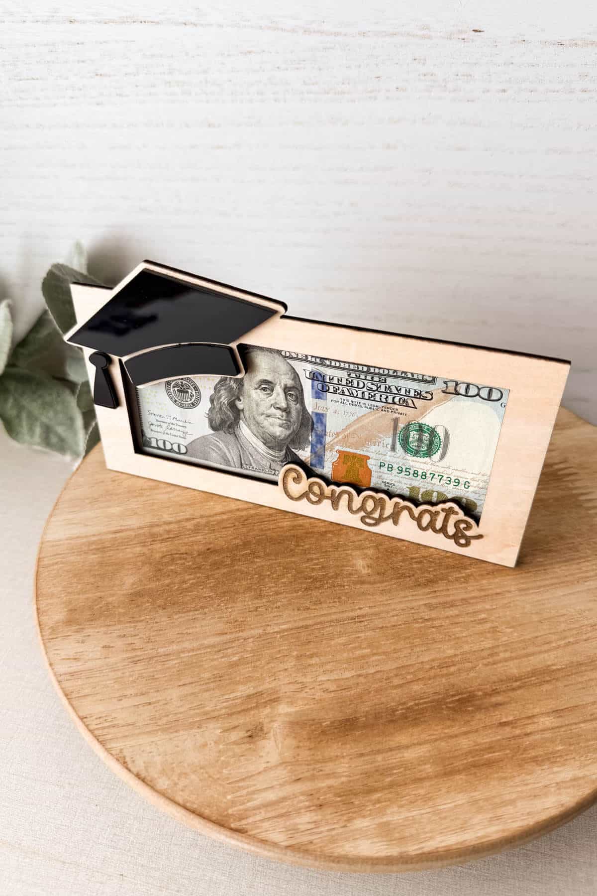 Vertical image of a wood and acrylic money holder for graduation made on the xTool M2 color craft.