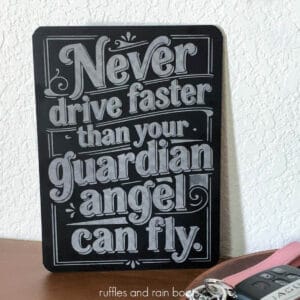 Close up square image of a dollar store chalkboard engraved with the xTool M2 laser which reads never drive faster than your guardian angel can fly in a vintage style.