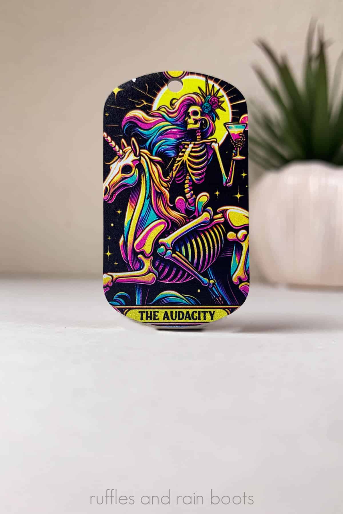 Vertical image of a very colorful skeleton woman riding a unicorn and drinking a margarita printed in UV ink with black light reactive properties.